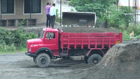 Pune, India - August 18 2021: A Dumper truck being filled up with sand in an open field at Pune India.