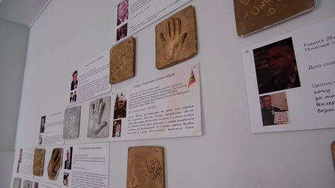 KAZAN, TATARSTAN RUSSIA - MAY 14 2021: Palms moulds and pictures with biographies of famous actors and actresses hang on wall in light cinema lobby room closeup on May 14 in Kazan