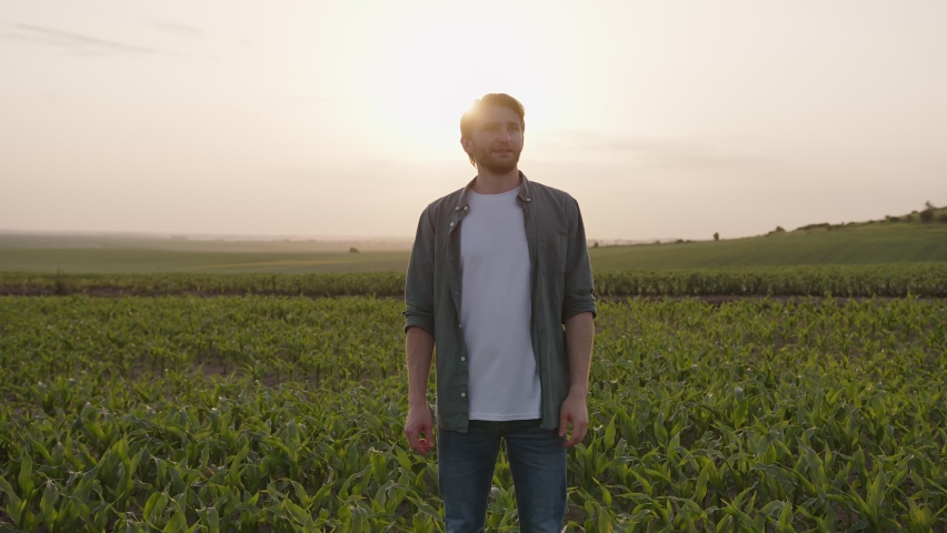 Happy man stand on a field and deeply breath, crosses his hands