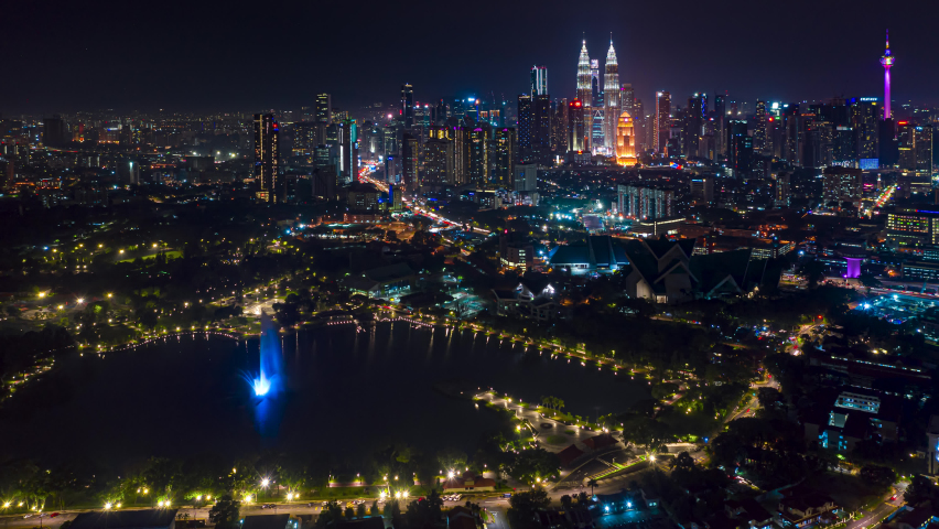 City Night Time lapse: Beautiful Kuala Lumpur city view with slight mist at night overlooking KL skyline with a big fountain in Titiwangsa recreational city park in Malaysia. Prores 4K