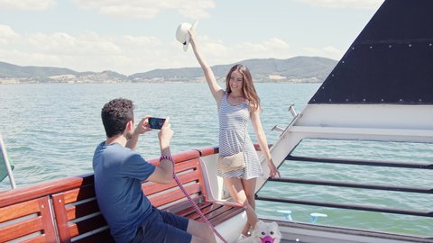 Happy couple taking pictures with smartphone on a boat trip