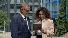 Business team man and woman working together outside. Boss and assistant holding tablet taking notes. Boss and secretary having consultation outdoor. - Powered by Shutterstock - Get 15% off with code: PIKWIZARD15