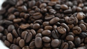 4k slow motion footage of bare hand pouring and screening of roasted coffee bean which taken in soft and multiple focus. Concept for use as an coffee product and shop advertisement and marketing.