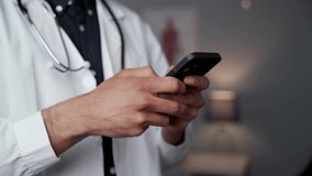Close up male doctor typing on cellular device