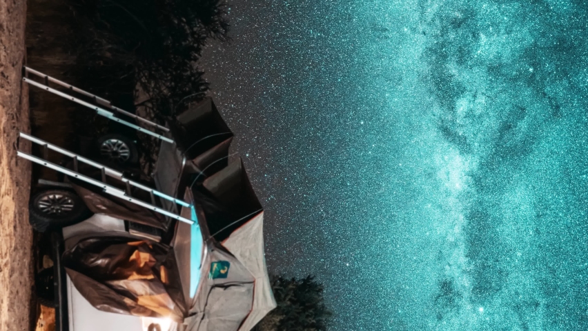 Vertical video. Astronomy Namibia starry landscape, travel in galaxy. Night timelapse of a safari vehicle in an adventurous wild camping location with rooftop tent against the Milky Way and starry sky