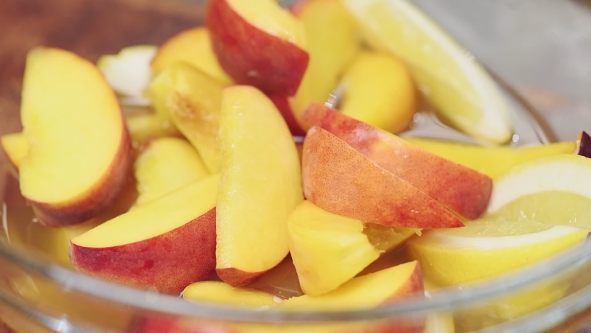 Adding leaves mint to the sliced fruit and green tea. Process of making iced fruit green tea.