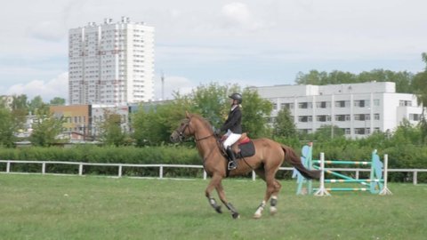 IZHEVSK, RUSSIA, AUGUST 07, 2021. Horse riders riding horses slow motion. Women in helmets horseman. Summer activity, sports at hippodrome with protection. Izhevsk Hippodrome. 4K UHD video