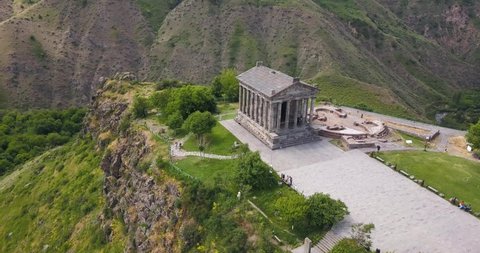 Video aerial view with panoramic panning of the famous Garni Temple in Armenia located in a picturesque place. Strong contrast filter and film grain added