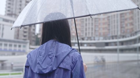 Brunette woman walking on street under rain with umbrella, bad mood, break-up