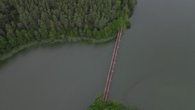 Fly over an old bridge over the river, narrow gauge railroad and forest in the rain. Nature concept.
