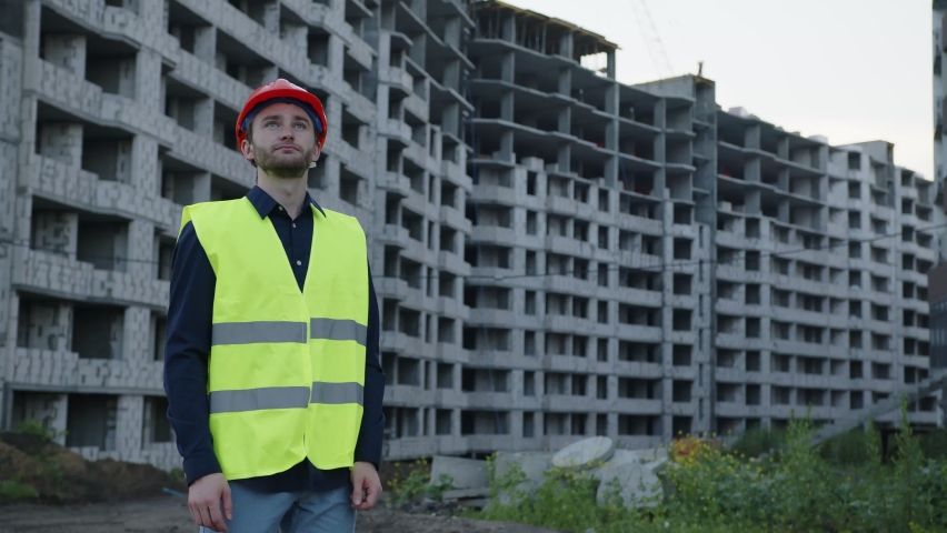 Young worker look on his new house project and crosses his hands
