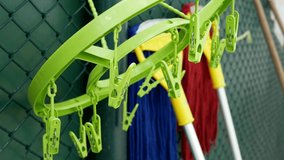 plastic cloth hanger with clothes pegs hanging on clothesline.