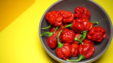 Freshly picked red scorpion peppers and placed in a ceramic container