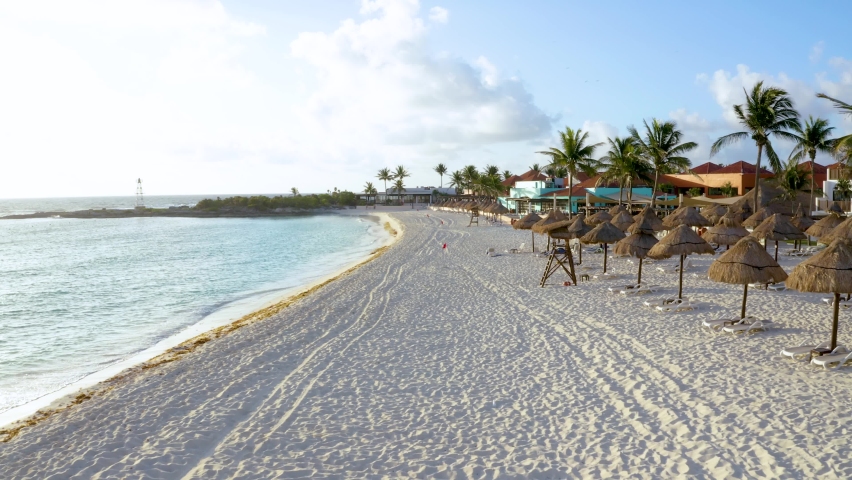 Flying down the beach in Mexico near Cancun town. View of luxury hotels, turquoise blue water and palm trees.