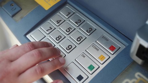 ATM Banking. Enter pin code in cash machine. Close up of person typing personal pin code in ATM cash machine.