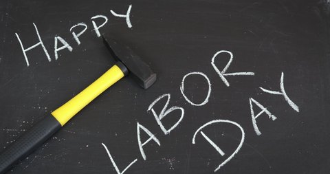 Celebration of labor day. A view of a mallet on the table by the words about happy labor day.