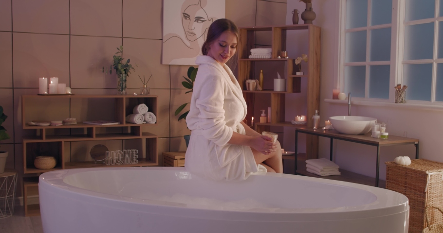 Beautiful young woman going to take bath with sea salt at home