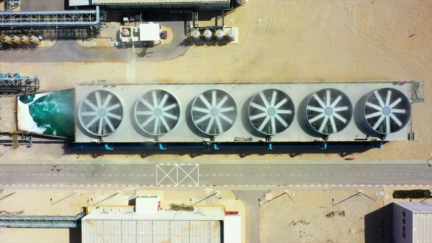 Aerial Top Lockdown Shot Of Fans Spinning Over Structure In Power Station On Sunny Day - Negev, Israel