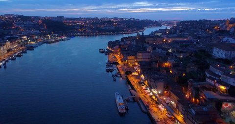 Aerial Backward Shot Of Train Moving On Famous Bridge Beautiful Illuminated In City - Porto, Portugal