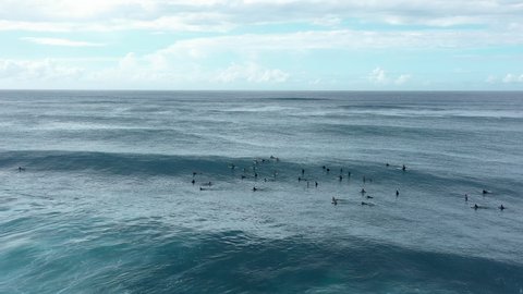 Aerial Reversing Over A Group Of Surfers Paddling And Surfing Giant Crashing Waves With Bright Sun And White Foaming Surf - Oahu, Hawaii