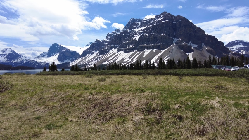 The view of snowy mountains and alpine Bow Lake in Banff National Park, Alberta, Canada. Beautiful scenery along Icefields Parkway in early summer. 