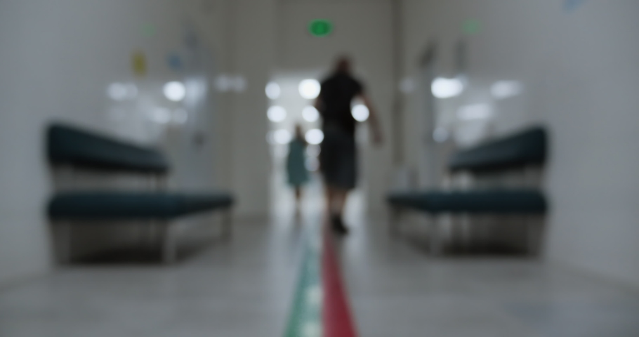 Hospital corridor, people move past the camera. Blurred shot. Concept: Hospital, Veterinary, Children's Clinic, Dentistry, Corridor.
