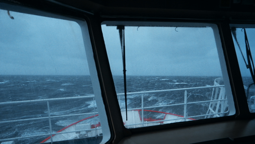 Ship in storm. View from bridge. Ship climb up wave. A lot of splashes on windows. Strong pitching. High waves hit ship. White foam on water. Royalty-Free Stock Footage #1077880274