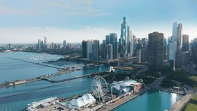 Chicago Illinois USA aerial drone footage of Chicago Navy Pier with Downtown skyscraper on cinematic background. Financial and residential buildings cityscape view on sunny summer day, 4K footage