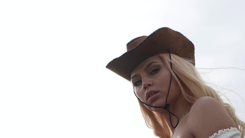 portrait of a blonde with big breasts and a cowboy hat. bottom view. close-up