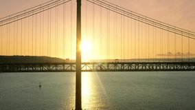 Ponte 25 de Abril, Lisbon, Portugal, Europe. Aerial view of picturesque sunset in the background of suspension bridge. A major landmark in Lisbon as seen from above. High quality 4k footage