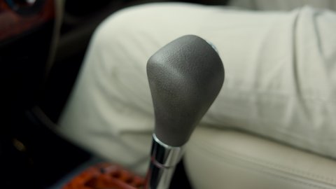Close up shot Young man hand control the stick shift transmission in luxury car. Male hand changing gear driving car.