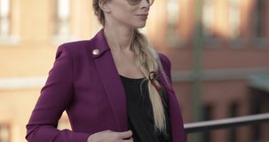 Cropped of trendy woman in purple jacket and black top.
