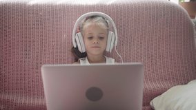 Little Girl Sitting Sofa in Headphones Listen music Use Laptop Have Fun Home Interior Caucasian Female Child Use Technology Modern Children 