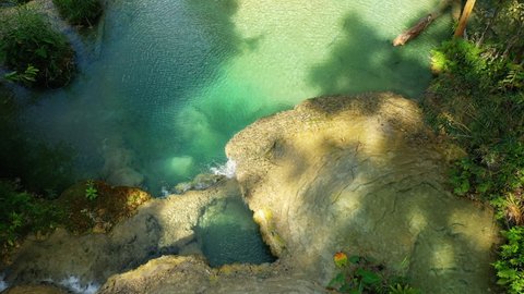 One of the translucent basins of Kuang Si Falls in Laos, towards Luang Prabang, before the rainy season, by drone.