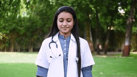 Portrait video of happy Indian woman  cardiologist show heart love shape with fingers smile look at camera. Care and support for private clinic patients, cardiology, healthcare concept