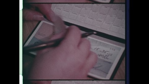 1970s Yonkers, NY. Close Up of Hand writing Personal Check and Tearing off Check from Checkbook. 1970s style woman writes cheque and pays for goods or services. 4K Overscan  Vintage Archival 16mm Film