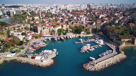 Aerial photograph of Antalya bay in Antalya city from high point of drone fly on sunny day in Turkey. Amazing aerial cityscape view from birds fly altitude on beautiful town and sea full of yahts
