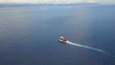 Aerial drone video of public ferry. Carrier ship cruising in indian ocean. Deep blue ocean sea