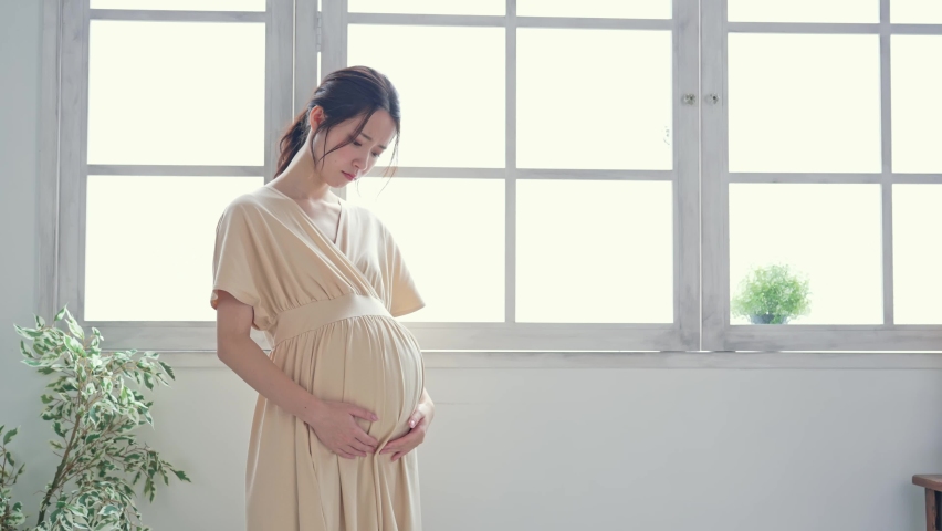 Thinking pregnant Asian woman concept. Maternity melancholy. Royalty-Free Stock Footage #1077946970