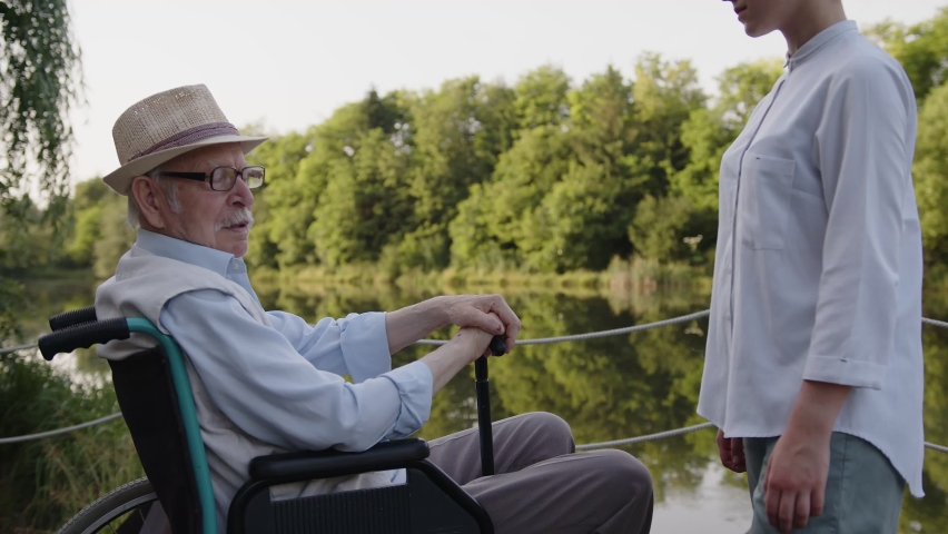 Big support of a young nurse, man in wheelchair, sit and think