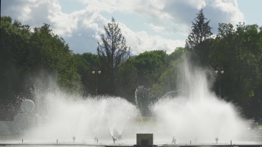 Water from the fountain. Top of high water stream of fountain behind cloudy sky. Fountain in river against dramatic sky. Cityscape view.