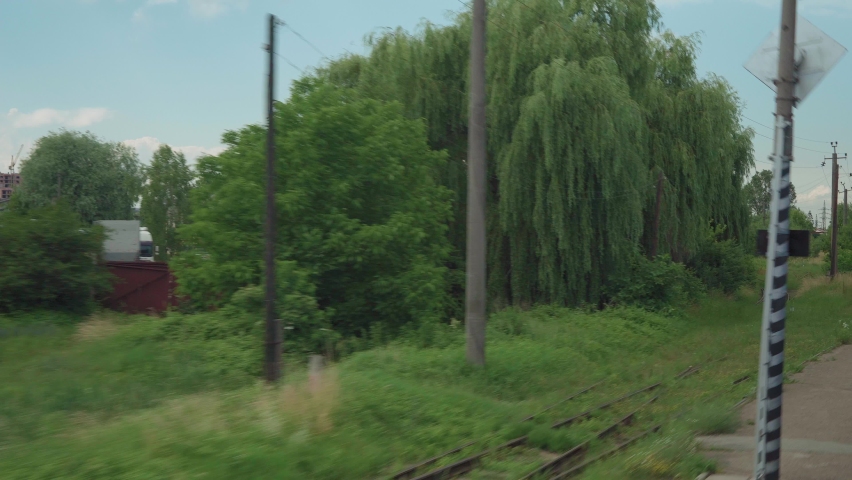 view from window high-speed train on landscape of beautiful nature wild field and forest railroad tracks rails clean sunny day in summer background. Transport, travel, railway, communication concept