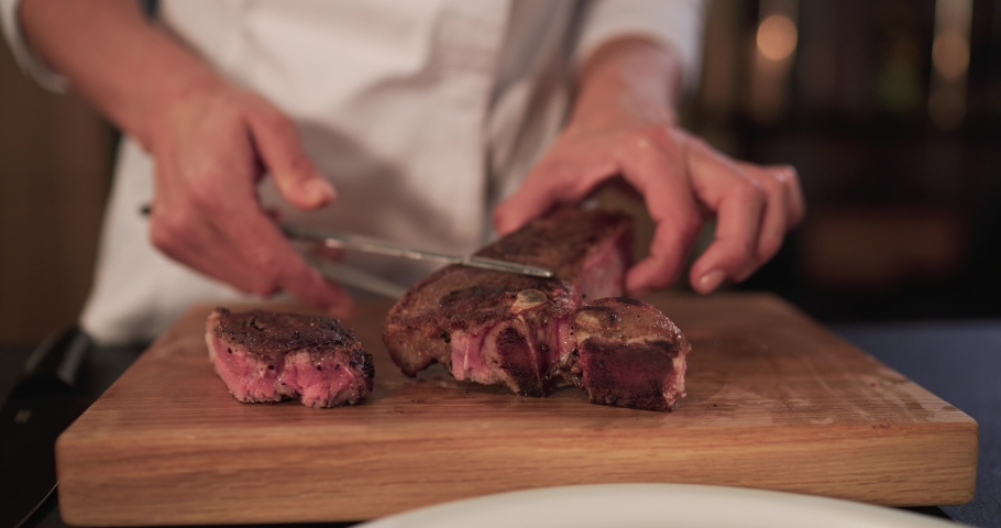 Cutting the meat. fresh raw red beef meat on chopping board. Beef steak cooked medium well cut sliced knife on a cutting board. A piece of steak being cut	
