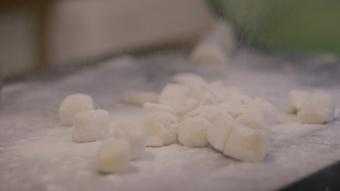 Chef sprinkling flour on gnocchi slowmotion
In a closed shot, we see in slow motion the sprinkling of flour, on the gnocchi on the wooden board