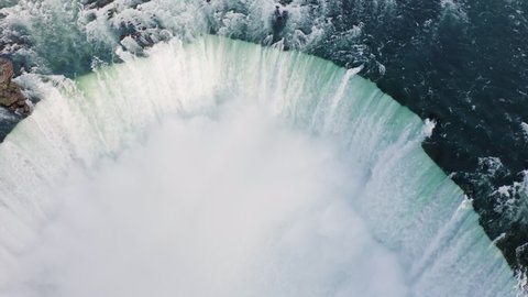 Aerial shot of huge water flows down the waterfall, Horseshoe Water Fall in Niagara, afternoon light