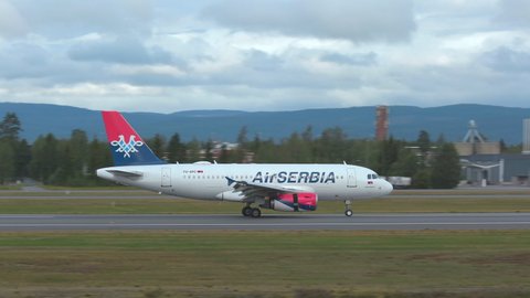 Oslo Airport Norway - August 16 2021:  airplane airbus 319 air serbia on ground passing by panning right