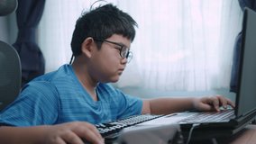 Asian boy is playing games with a laptop in a room. Massively Multiplayer Online Game, child 10 years