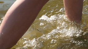 Woman or girls legs walking barefoot on beach coastline in shallow water. Meditation on retreat concept. Full HD slow motion video.