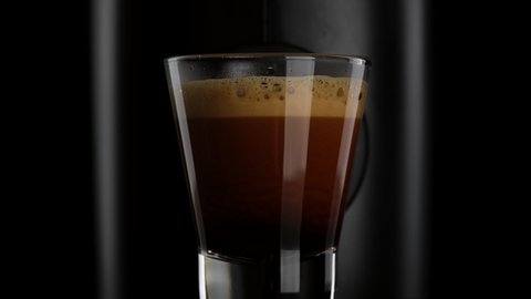 Black coffee with froth. Making black coffee espresso or ristretto in coffee machine. Home making hot Espresso. 4K UHD video