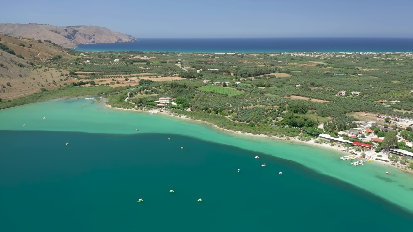 Aerial view of a large freshwater lake surrounded by arid mountains (Lake Kournas, Crete, Greece)